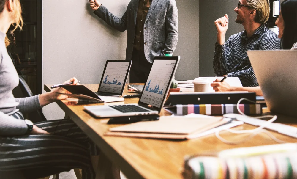 Colleagues discussing ideas around a table in a shared workspace