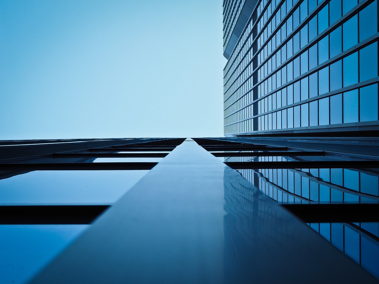 Blue sky reflected in the glass facade of a modern building